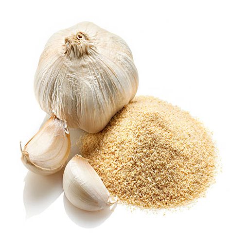 Studio shot of a mound of dried garlic with whole garlic and two fresh garlic cloves.  Shot on white background with reflective shadow.